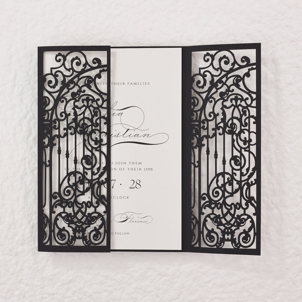 Black laser cut wedding invitation with a gate design. The invitation reads 'With their families, [Name] and [Name] join them on the celebration of their love, [Date], [Time], [Location] to follow.'
